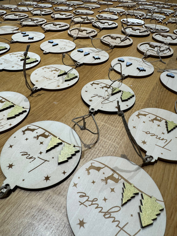 Boule de Noël personnalisée en bois gravé, décoration festive unique pour le sapin, idéale comme cadeau ou souvenir de fête.