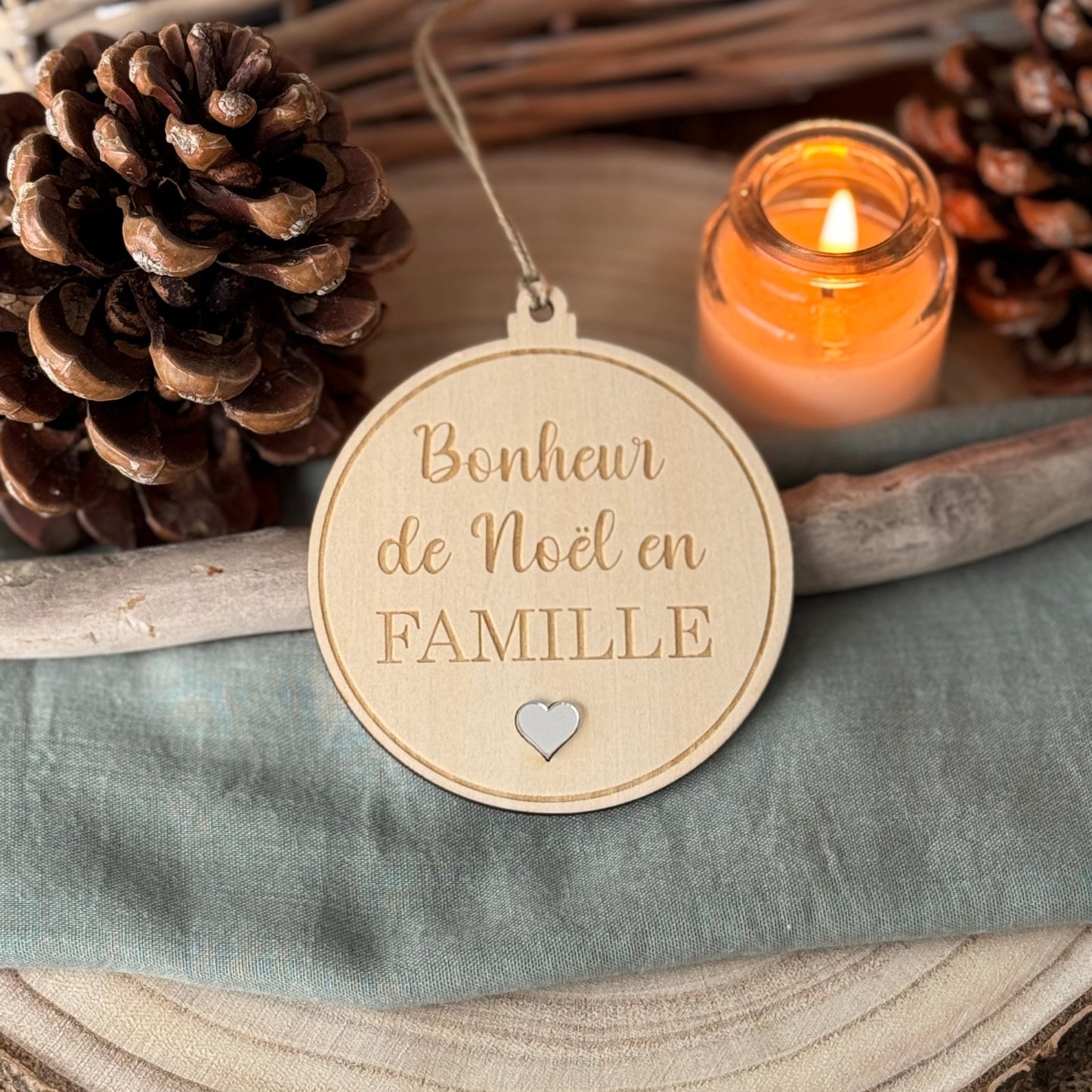 Boule de Noël en bois, avec la gravure "Bonheur de Noël en FAMILLE" , un petit coeur en dessous du texte en relief argent miroir