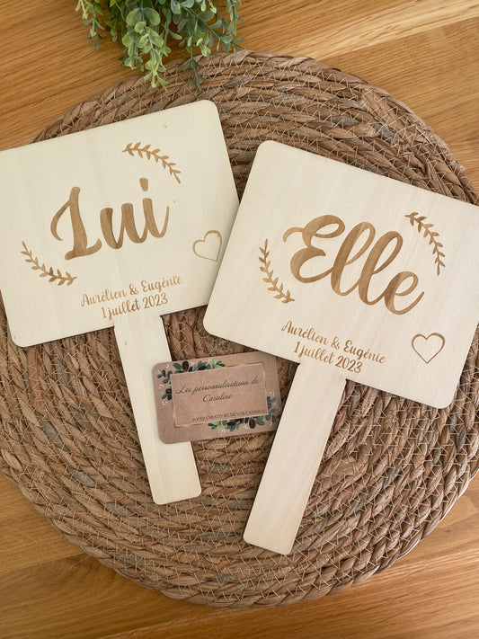 pancartes en bois gravées pour le jeu des mariés, personnalisées avec prénoms et date du mariage.